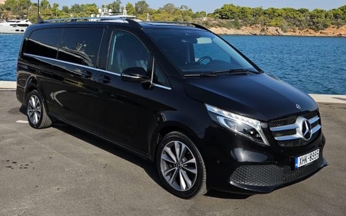 Black Mercedes-Benz V-Class passenger van of the MX Transfers fleet parked by the marina