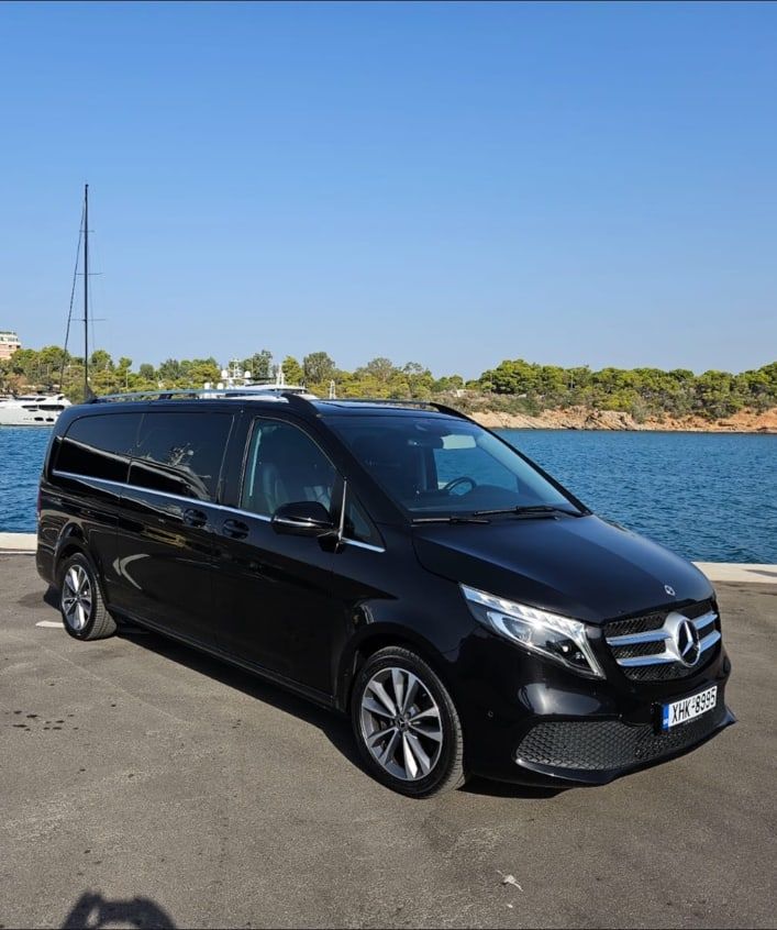 Black Mercedes-Benz V-Class passenger van of the MX Transfers fleet parked by the marina