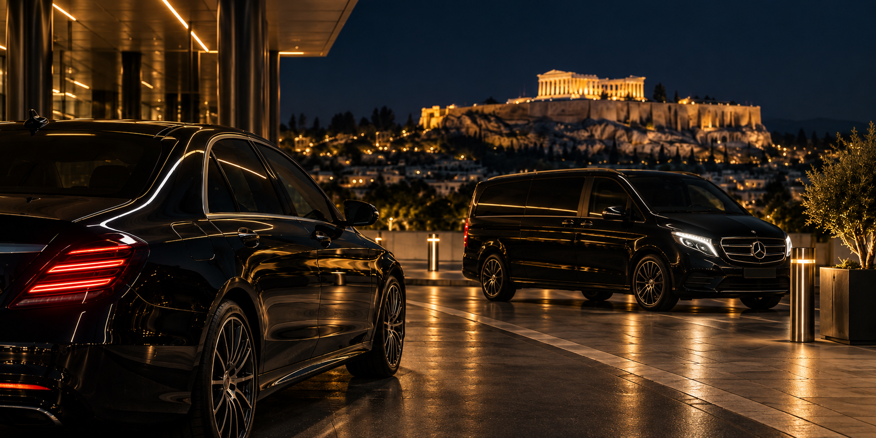 A black Mercedes-Benz sedan and V-Class van of the MX Transfers fleet on a lit plaza at night, with the illuminated Acropolis of Athens behind them